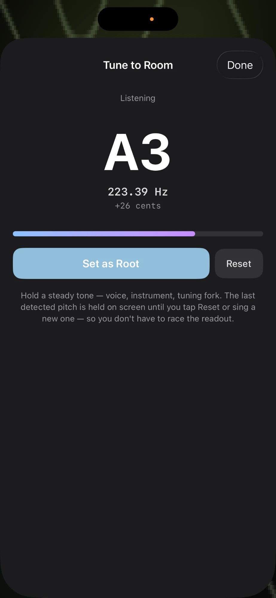 The Tune to Room sheet with a Done button in the corner, a Listening label, a very large note readout (A3), the detected frequency (223.39 Hz) and offset (+26 cents) below it, a blue-to-pink gradient level meter, and the blue Set as Root primary button next to a smaller Reset button. Below: 'Hold a steady tone — voice, instrument, tuning fork. The last detected pitch is held on screen until you tap Reset or sing a new one — so you don't have to race the readout.'